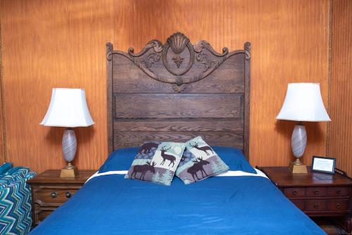 a bedroom with a blue bed with two lamps at Boulderdash Cabin in Bandera