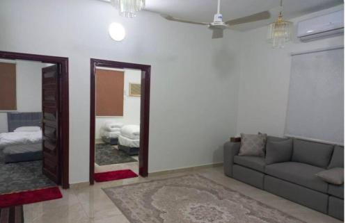 a living room with a couch and a mirror at Alfatih apartments شقق الفتح in Al Madinah