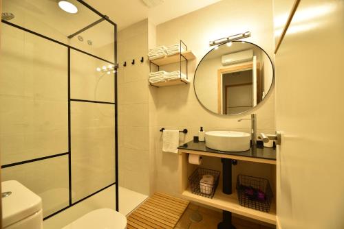 ein Badezimmer mit Dusche, Waschbecken und Spiegel in der Unterkunft Apartamento Playa La Barrosa in Chiclana de la Frontera