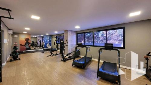 a gym with several treadmills and machines in a room at Studio completo e bem localizado in Jaú