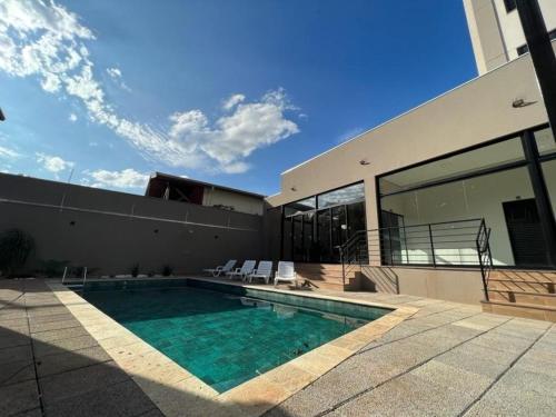 a house with a swimming pool next to a building at Studio completo e bem localizado in Jaú