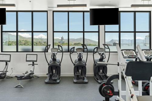 a gym with cardio equipment in a room with windows at Top floor Deluxe 1BR Pool,Gym,Htub,Bowling and More in Salt Lake City