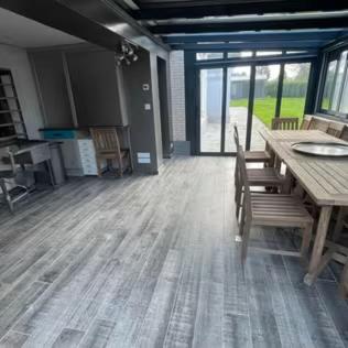 une chambre vide avec une table et des chaises en bois dans l'établissement Le Presbytère Normand, à Canapville