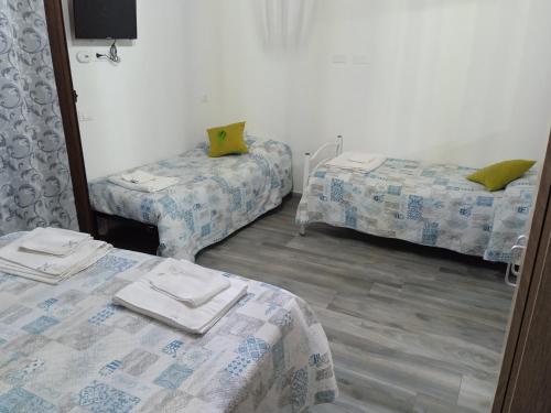 a room with two twin beds and a mirror at Alla cattedrale home in Agrigento