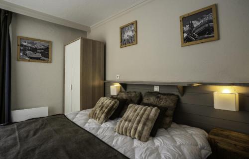une chambre avec un lit avec deux oreillers dessus dans l'établissement Chalet Rosael - Appartement plein sud au pied des pistes MAE-1561, à Val Thorens