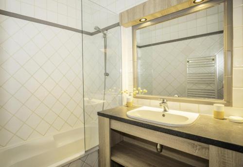 une salle de bain avec un lavabo et une baignoire dans l'établissement Chalet Alaska - Appartement familial tout confort avec piscine MAE-9531, à Val Thorens