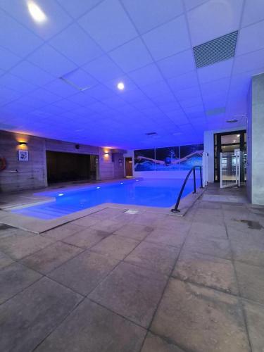 une piscine vide dans un bâtiment avec un plafond bleu dans l'établissement Chalet Alaska - Appartement familial tout confort avec piscine MAE-9531, à Val Thorens