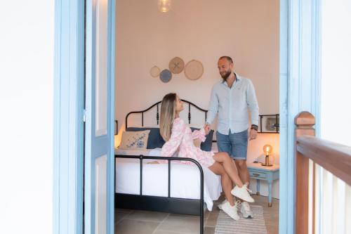 a man and a woman standing next to a bed at 7Kamares in Pano Lefkara