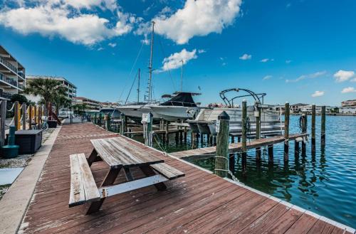 a wooden dock with a boat in the water at Charming and Spacious Studio in Clearwater Beach