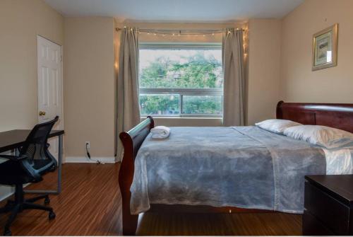 a bedroom with a bed and a window and a desk at Downtown Retreat-Spacious Rooms with Shared Kitchen & Bath in Toronto
