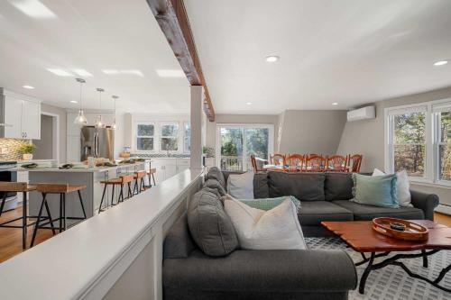 a living room with a couch and a kitchen at Unique A Frame Short Drive to Beach in Barnstable