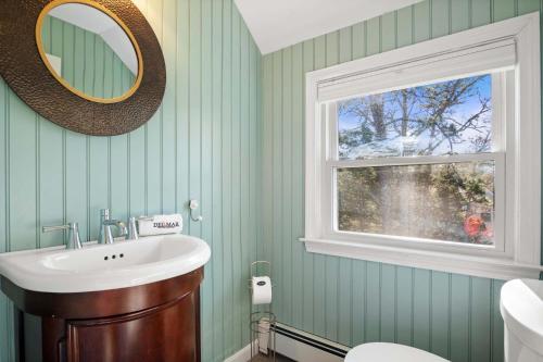 a bathroom with a sink and a window at Unique A Frame Short Drive to Beach in Barnstable