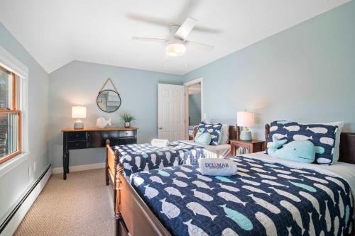 a bedroom with two beds and a desk in it at Unique A Frame Short Drive to Beach in Barnstable