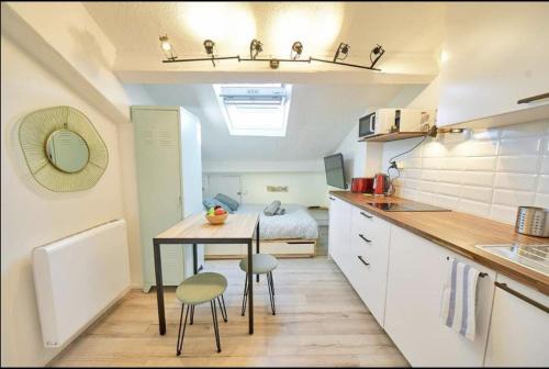 une petite cuisine avec une table et des chaises dans une pièce dans l'établissement Sweet Wilson Salengro - droit, à Villeurbanne