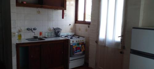 a small kitchen with a stove and a sink at departamento en Valeria del mar in Valeria del Mar