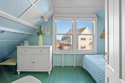 a bedroom with a bed and a window with a house at Walk to Private Bayside Beach in Brewster