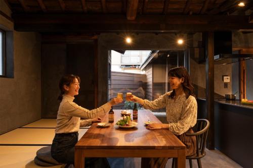 静岡市にあるTown Stay 456 - Vacation STAY 26662vの二人の女性が飲み物を飲みながら座っている