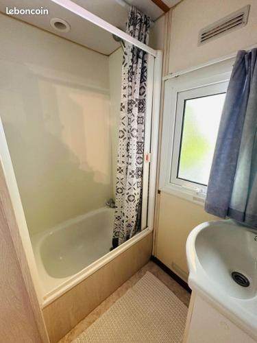 une salle de bain avec une douche, une baignoire et un lavabo dans l'établissement Mobil Home Climatisé Menthe à l'eau, à Biscarrosse