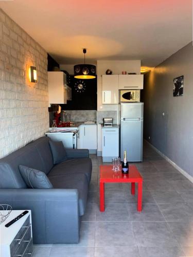 - un salon avec un canapé et une table rouge dans l'établissement Résidence Port Nature Colline 8 - Studio 2 pers- Port Nature Colline 8 MAE-6194, au Cap d'Agde