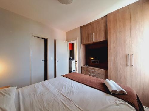 a bedroom with a bed and wooden cabinets at LK Barro Preto 11 in Belo Horizonte