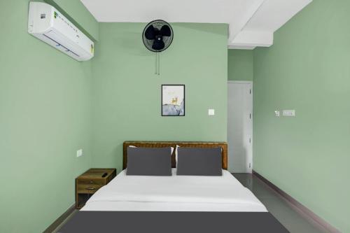 a bedroom with a bed and a fan at Super Hotel O Olive Residency in Calicut