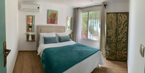 a bedroom with a bed with blue pillows and a window at Palmeraie 3 in Skhirat