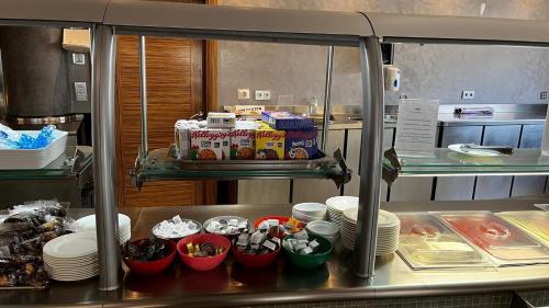a kitchen with plates and bowls of food on a counter at Cumbria Spa Hotel 3* Sup in Ciudad Real