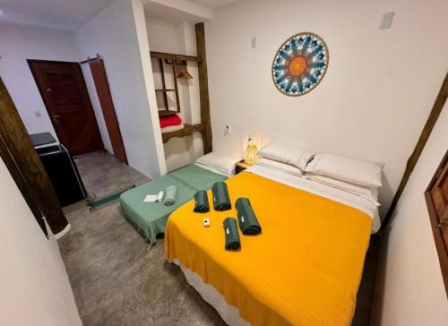 Ein Zimmer mit einem großen gelben Bett und einem Zimmer mit einer Fläche von 1 m2 in der Unterkunft Noronha Pura Vida in Fernando de Noronha