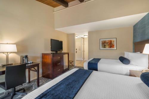a hotel room with two beds and a flat screen tv at Best Western Plus Carpinteria Inn in Carpinteria