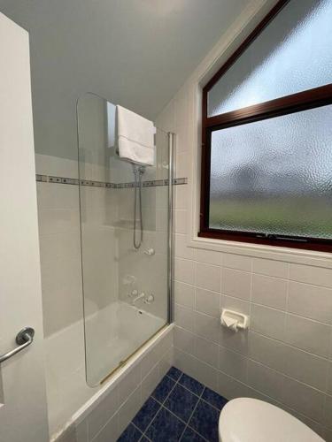 a bathroom with a shower and a toilet and a window at Ravensbourne Escape- Quingilli in Ravensbourne
