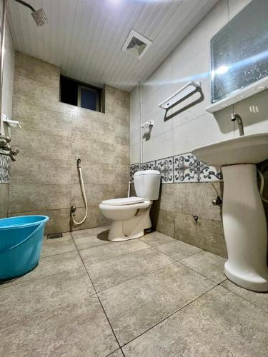 a bathroom with a toilet and a sink and a tub at Rysons Continental Hotel in Rawalpindi
