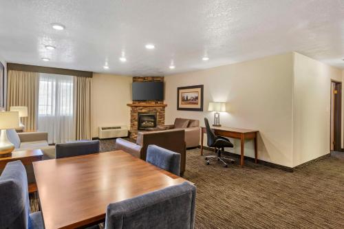 a hotel room with a table and chairs and a fireplace at Best Western Plus Landmark Inn in Park City