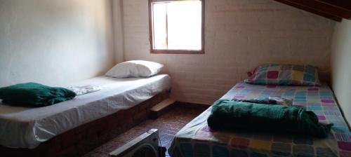 two beds in a small room with a window at departamento en Valeria del mar in Valeria del Mar