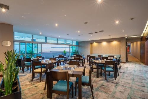 a restaurant with tables and chairs in a room at Estelar Apartamentos Medellin in Medellín