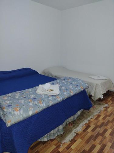 a bed with a blue comforter and a table at Villarrica in Valle Hermoso