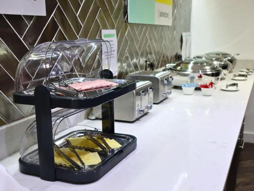 a buffet line with a counter with plates and pans at Garner Hotel Preston Samlesbury by IHG in Preston