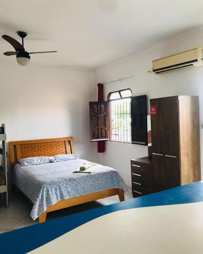 a bedroom with a bed and a dresser and a window at Pousada Apart Fraga Maia in Feira de Santana