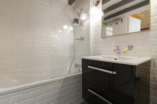 une salle de bain blanche avec un lavabo et une douche dans l'établissement Le Duplex Central tout équipé, à Toulouse