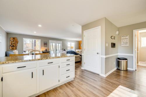 a kitchen with white cabinets and wood floors at Private Boat Dock Troutman Home on the Water! in Terrell