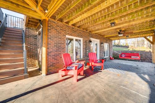 a patio with two red chairs on a brick wall at Private Boat Dock Troutman Home on the Water! in Terrell