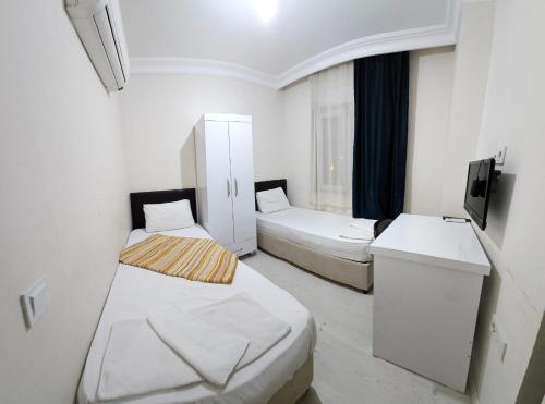 a small room with two beds and a sink at KARTALKAYA APART OTEL in Antalya