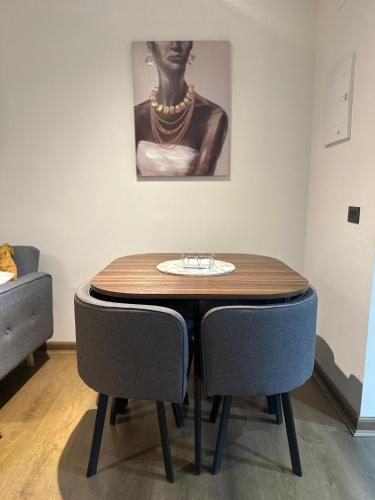 a table and chairs in a room with a painting at Amplio departamento en zona céntrica de Concepción in Concepción