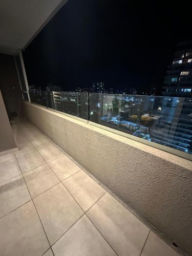 a balcony with a view of a city at night at Amplio departamento en zona céntrica de Concepción in Concepción