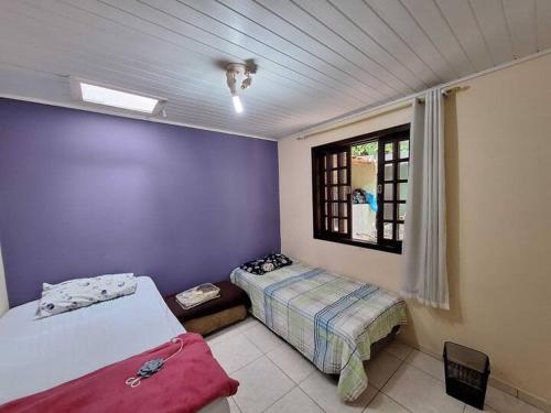a bedroom with two beds and a window at Casa aconchegante em Curitiba in Curitiba