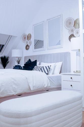 a white bedroom with a white bed and a white dresser at Boho Chic Home in Town Center in Viersen