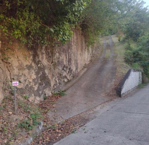 a dirt road with a sign next to a wall at Seaview Guesthouse Apt #2 in Plymouth