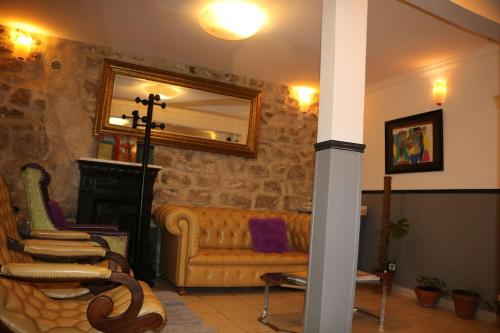 a living room with a couch and a mirror at Hotel Clermont Montmartre in Paris