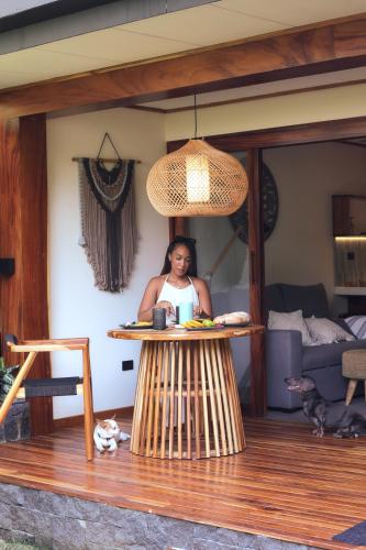 a woman sitting at a table in a living room at Wabi Sabi Hana in Punta Uva