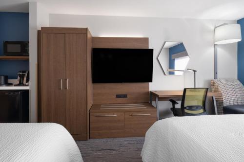 a hotel room with a television and a desk with a bed at Holiday Inn Express Sheboygan-Kohler / I-43 by IHG in Sheboygan