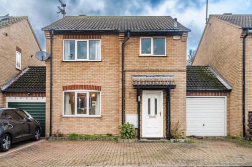 a brick house with a car parked in front of it at J&J stays 5 bedroom detached house in Peterborough with parking in Peterborough